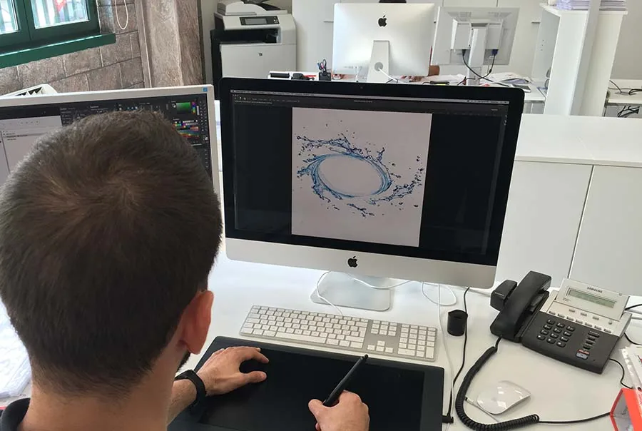 Operatore dell'ufficio grafico al lavoro su un file con la tavoletta grafica